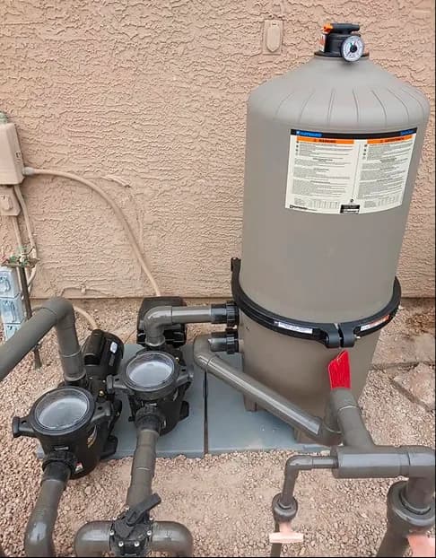 Pool filter and pump plumbing installed beside house